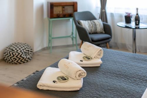 a room with towels and a chair and a table at Polai Panorama Apartments with FREE Parking in Pula