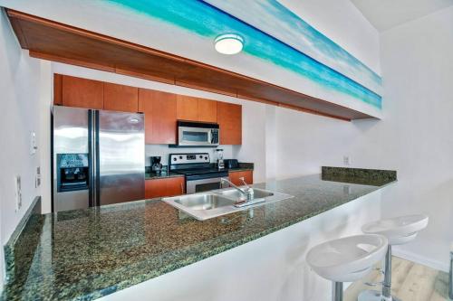 a kitchen with a sink and a counter with stools at Amazing Penthouse In beautiful Brickell 42 floor!! Free Garage Parking in Miami