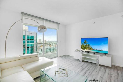 a living room with a white couch and a flat screen tv at Amazing Penthouse In beautiful Brickell 42 floor!! Free Garage Parking in Miami