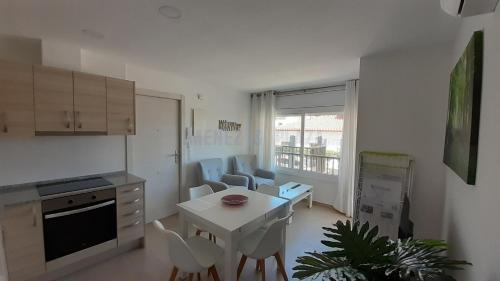 a kitchen with a table and chairs in a room at Apartamentos Dins Mar Apto. 2 in Torredembarra