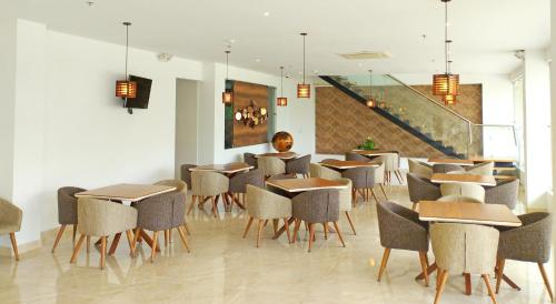 a restaurant with tables and chairs and a staircase at Hotel Royal Elim International in Cali