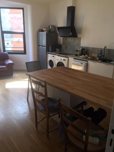 une cuisine avec une table en bois et deux chaises dans l'établissement Appartement 67 M2 COMEDIE Centre Ville MONTPELLIER, à Montpellier