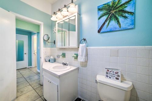 ein Badezimmer mit einem Waschbecken und einer Palme an der Wand in der Unterkunft Walk to Beach PCB Retreat with Private Pool! in Panama City Beach