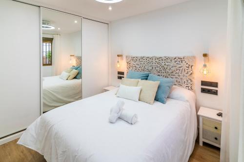 um quarto com uma grande cama branca e um espelho em Diemalía em Córdoba