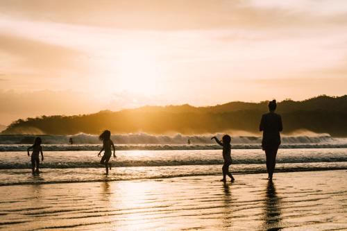 a group of people playing on the beach at sunset at Selina Playa Venao in Playa Venao