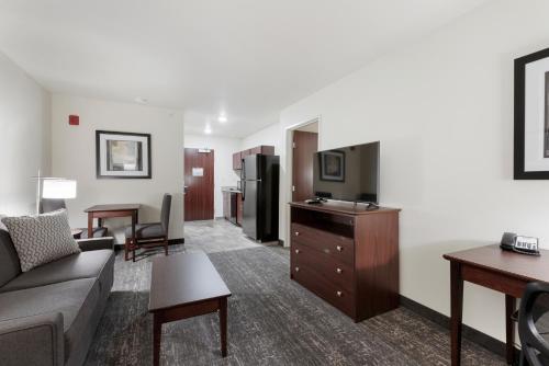 a living room with a couch and a flat screen tv at Cobblestone Hotel & Suites - Urbana in Urbana