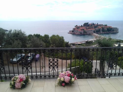 a balcony with a view of a castle and the ocean at Vila Horizont in Sveti Stefan