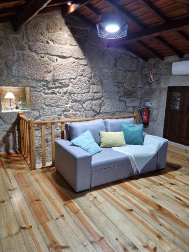 kanapa w pokoju z kamienną ścianą w obiekcie Casa da Mimi w mieście Soajo