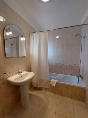 a bathroom with a sink and a shower and a tub at Apartamento Sunny Velamar in Patroves