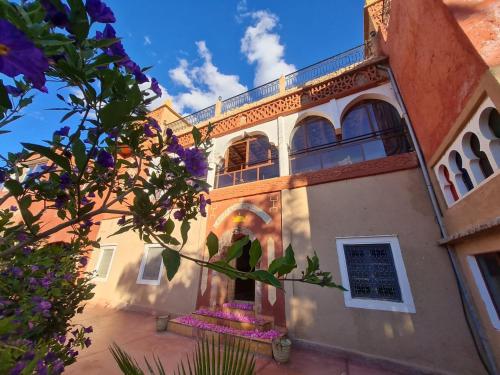 a building with purple flowers in front of it at Kasbah Chems in El Kelaa des Mgouna