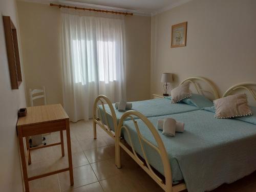 a bedroom with two beds and a table and a window at Apartamento Sunny Velamar in Patroves