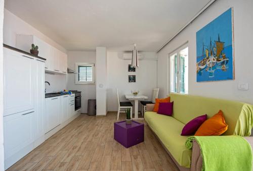 a living room with a green couch and a kitchen at Apartment Zora in Trogir