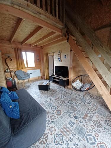 sala de estar con sofá y chimenea en Chalet chaleureux avec parking garage motos, vélos, en La Chapelle-aux-Chasses