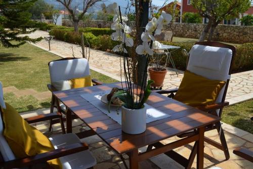 a wooden table with a vase of flowers on it at Paloma in Karavadhos