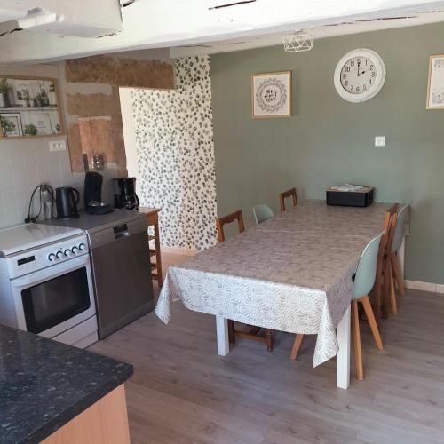 une cuisine et une salle à manger avec une table et une table et des chaises dans l'établissement Gîte Belle Fleur 6 personnes- Vosges, à Saint-Nabord