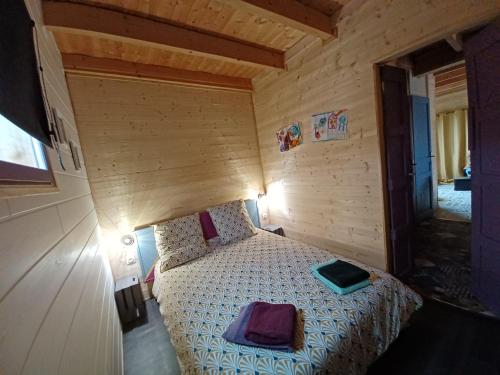 1 dormitorio con 1 cama en una habitación de madera en Chalet chaleureux avec parking garage motos, vélos, en La Chapelle-aux-Chasses