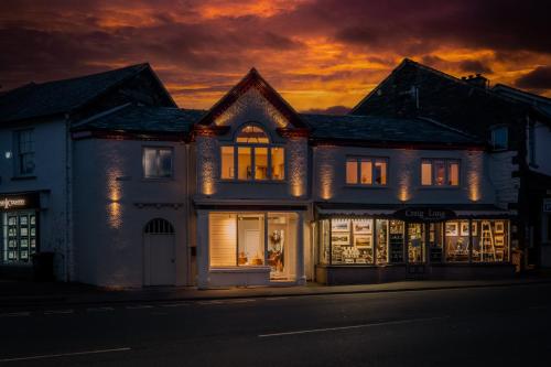 une maison avec des lumières dans les fenêtres la nuit dans l'établissement Craig's Suites, à Windermere