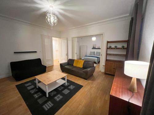 a living room with a couch and a bed at Chambres privées -Private room- dans un spacieux appartement - 100m2 centre proche gare in Mulhouse