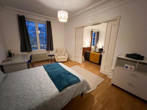 a bedroom with a bed and a chair in it at Chambres privées -Private room- dans un spacieux appartement - 100m2 centre proche gare in Mulhouse