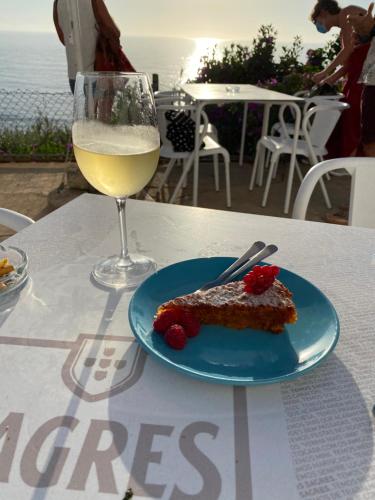 a piece of cake and a glass of wine on a table at Casa do Brejão campo e praia in Odemira