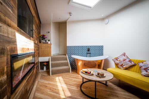 a living room with a yellow couch and a tv at Craig's Suites Windermere in Windermere