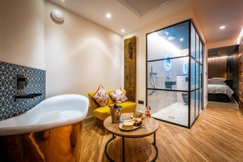 a bathroom with a tub and a table in a room at Craig's Suites Windermere in Windermere