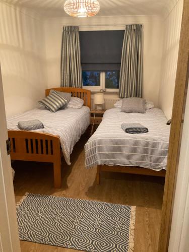 een slaapkamer met 2 bedden en een raam bij Quality Court in Langton Matravers