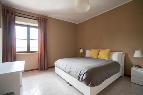 a bedroom with a bed with yellow pillows and a window at Gerosa Guest House in Lamezia Terme