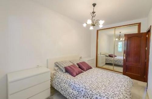 een slaapkamer met een bed, een dressoir en een spiegel bij Lilia Lauro Golf in Málaga