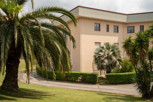 a building with palm trees in front of it at Gerosa Guest House in Lamezia Terme