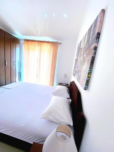 a bedroom with a large white bed and a window at Apartmani Kovačević in Kotor