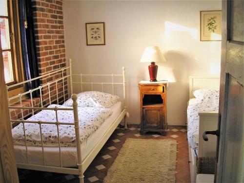 1 dormitorio con 2 camas y una lámpara en una mesa en Fischerhaus Godewind 60 qm, en Altwarp