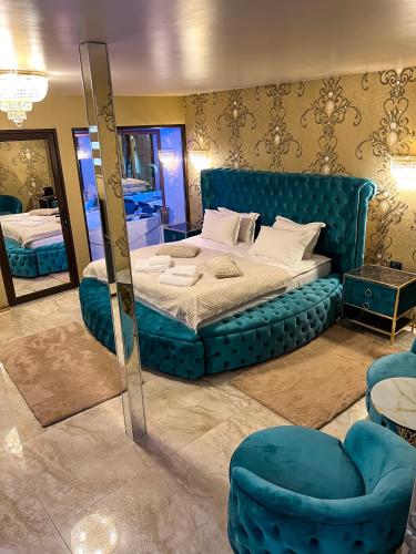 a bedroom with a blue bed and a mirror at Cetate Residence in Braşov