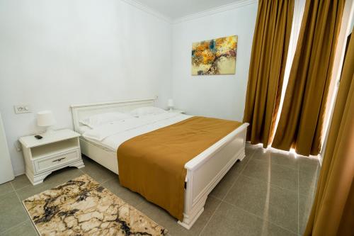 a bedroom with a white bed with a yellow blanket at Armada Aparthotel in Alba Iulia
