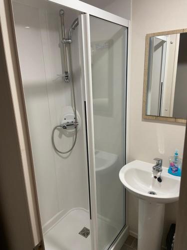 a bathroom with a shower and a sink at The Cedar lake Southview Skegness in Lincolnshire