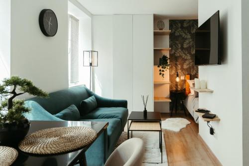 uma sala de estar com um sofá azul e uma mesa em La DOLCE Villetta - appartement de Standing em Mulhouse
