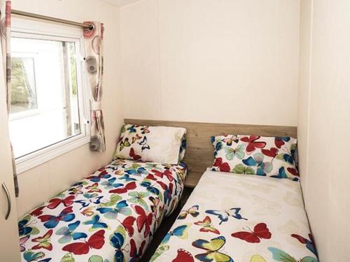 een kleine kamer met een bed en een raam bij The Cedar lake Southview Skegness in Lincolnshire