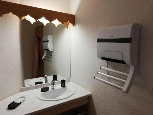 La salle de bains est pourvue d'un lavabo et d'un distributeur de serviettes en papier. dans l'établissement Le repère des écureuils, à Samoëns