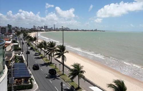 a view of a beach with palm trees and the ocean at Suíte INDIVIDUAL com Ar condicionado em AP Compartilhado in João Pessoa