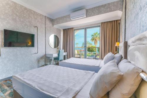 アランヤにあるWien Star Hotelのベッド2台とソファが備わるホテルルームです。