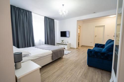 a bedroom with a bed and a blue couch at Armada Aparthotel in Alba Iulia