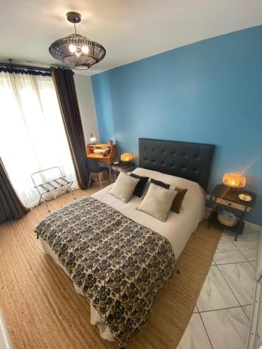 - une chambre avec un grand lit et un mur bleu dans l'établissement Chambres d'hôtes du Parc Bordelais, à Bordeaux