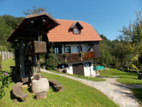 a small house with a wooden roof on a yard at APARTMANI Etno kuća pod Okićem in Samobor