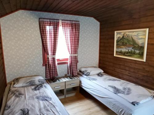 1 dormitorio con 2 camas individuales y ventana en Norway Stabben Tour, en Tustna