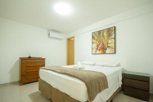 a bedroom with a bed and a dresser and a painting at Sua casa fora de casa! in Angra dos Reis