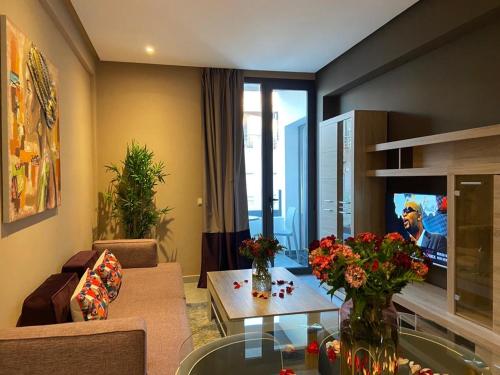 a living room with a couch and a table with flowers at Atlas-Résidence by Rent-Inn in Rabat