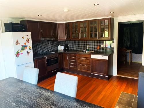 a kitchen with wooden cabinets and a white refrigerator at Norway Stabben Tour in Tustna