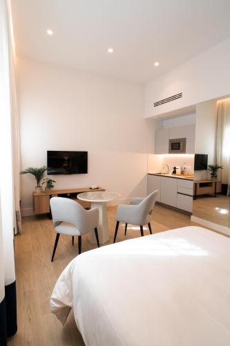 a bedroom with a bed and a table and chairs at CISNES PALACE in Sanlúcar de Barrameda