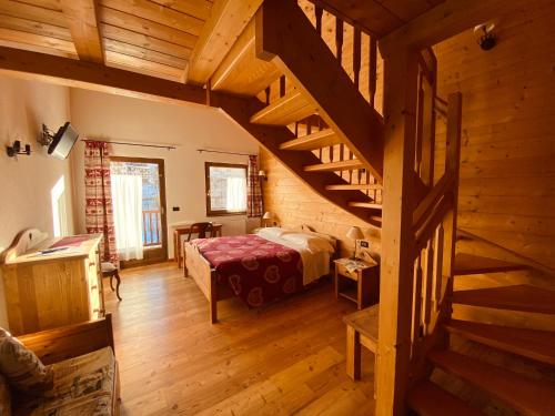 a bedroom with a bed and a staircase in a room at Hotel L'Artisin in Limone Piemonte