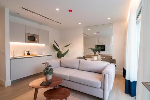 a living room with a white couch and a kitchen at CISNES PALACE in Sanlúcar de Barrameda